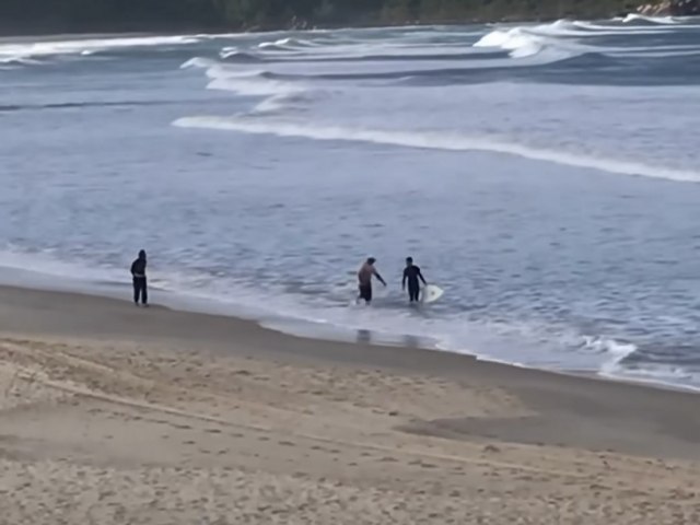 Surfista  impedido de entrar na gua por pescador durante a safra da tainha